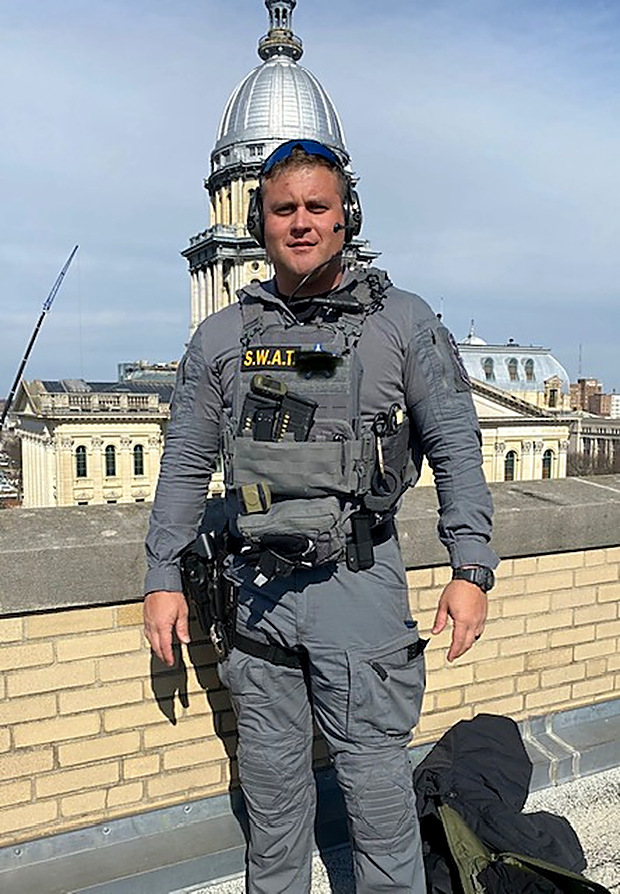 Cody Rose in SWAT kit on a rooftop overlooking the Illinois State Capitol